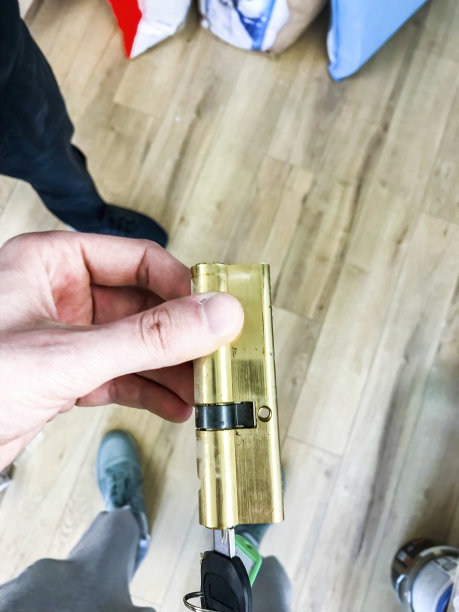 黄铜圆柱形机械锁系统，钥匙在男士手中。安全。门。在里面。安全的。修复。核心。技术图片下载
