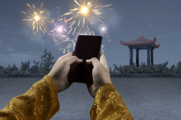 手持手机与烟花在夜景背景图片下载