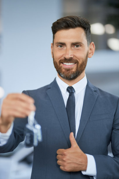 一名男子竖起大拇指，拿着新车的钥匙图片下载