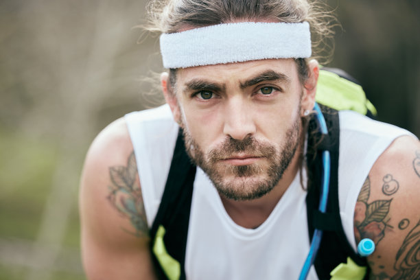 一个英俊的年轻男性运动员在他的晨跑期间休息的剪裁肖像图片下载