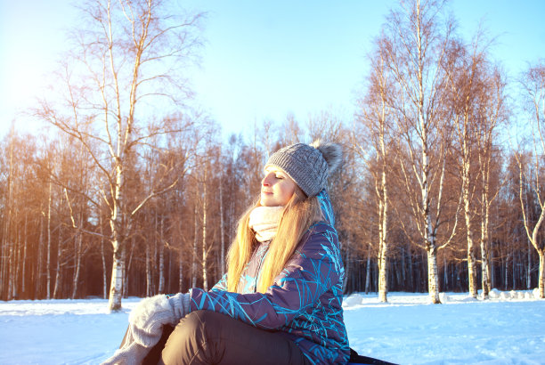 一个快乐的女性旅行者的肖像日光浴和欣赏美丽的冬季风景在一个阳光明媚的日子图片下载