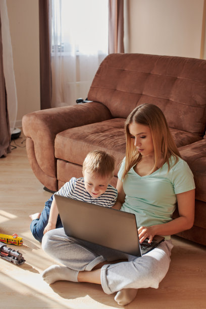 年轻的妈妈带着孩子在笔记本电脑上学习图片下载