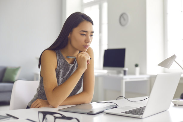 沉思的数字艺术家，网页设计师或照片修图师使用平板电脑和笔记本电脑工作图片下载