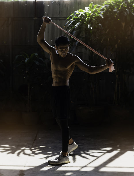 身材健美的年轻人，拉着粉色的橡皮线在拉伸图片下载