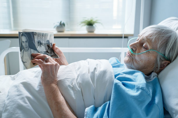 生病的老女人在看她的旧照片图片下载