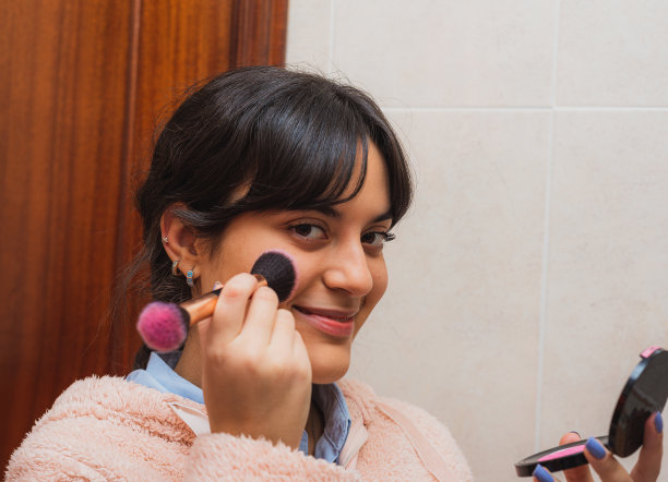 年轻女子在镜子前化妆图片下载