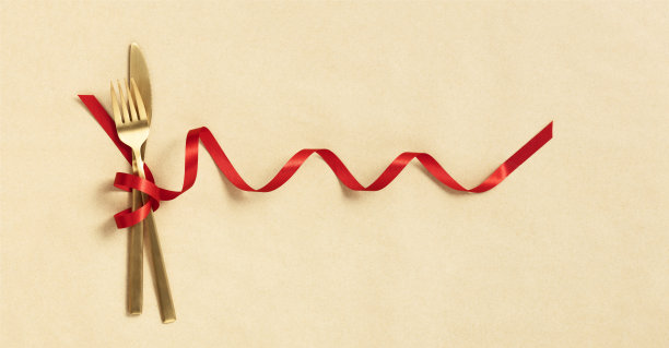 用红丝带系着的刀叉。食物，餐厅和餐桌设置主题模板图片下载