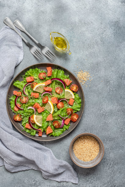鲑鱼沙拉，新鲜蔬菜和橄榄油。灰色混凝土grunge背景。俯视图，平躺。垂直的照片。图片下载