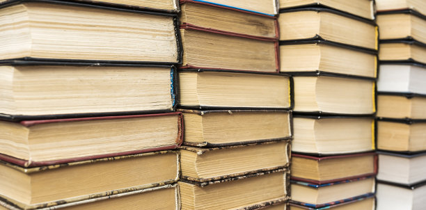 图书馆大厅的木桌和模糊书架上堆满了书图片下载