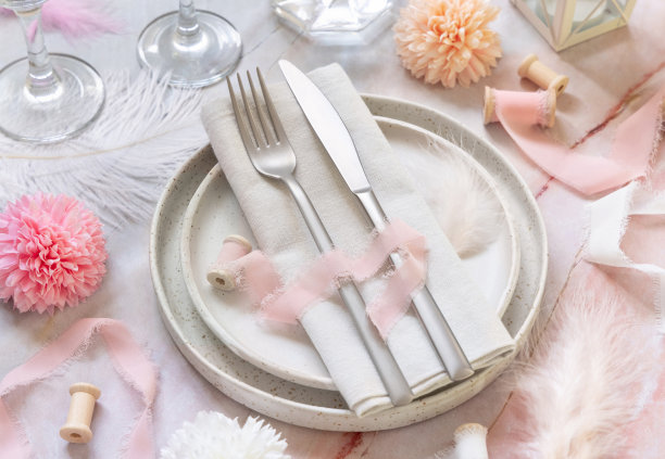 婚礼桌放置在大理石桌子上，靠近鲜花，丝绸缎带和羽毛图片下载