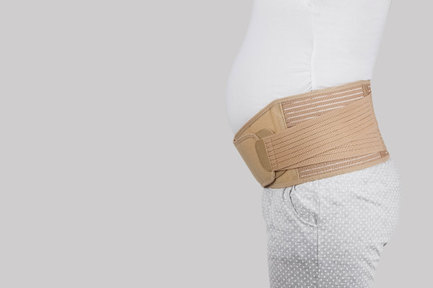 孕妇肚子在产前带孕带孕。骨科腹部支撑腰、背、腹带。怀孕用的腹部支撑或带。水平网络横幅。怀孕模特躯干图片下载