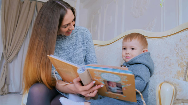 年轻的母亲和她的儿子在看相册图片下载