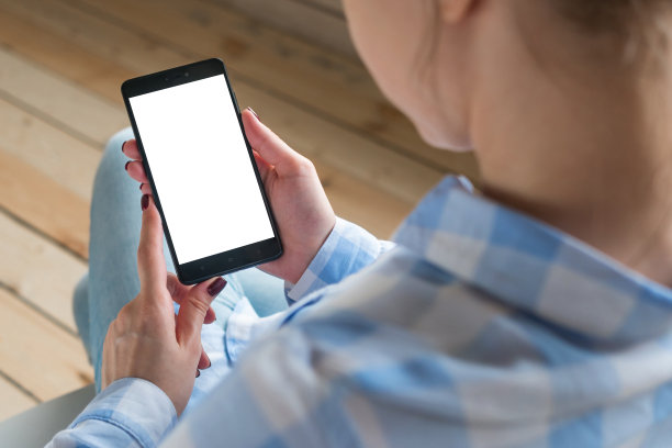 一个女人在看智能手机，手机的白色屏幕是空的图片下载