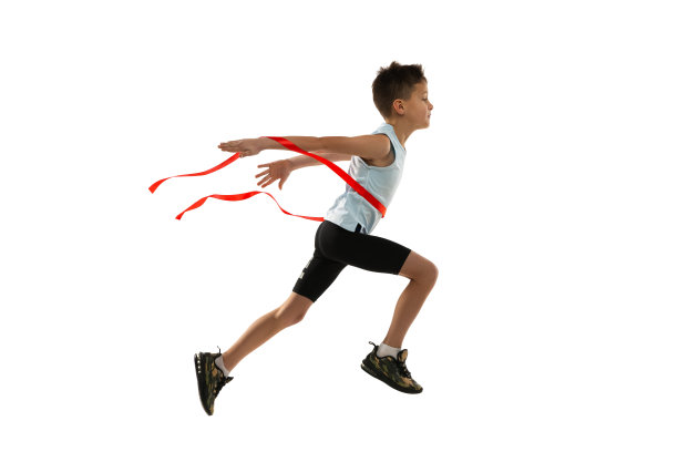 侧视图工作室拍摄的少年运动，跑步运动员跨越赢得红色丝带孤立在白色背景图片下载