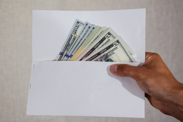 钱装在一个男人的白色信封里。美元，一叠美元。图片下载