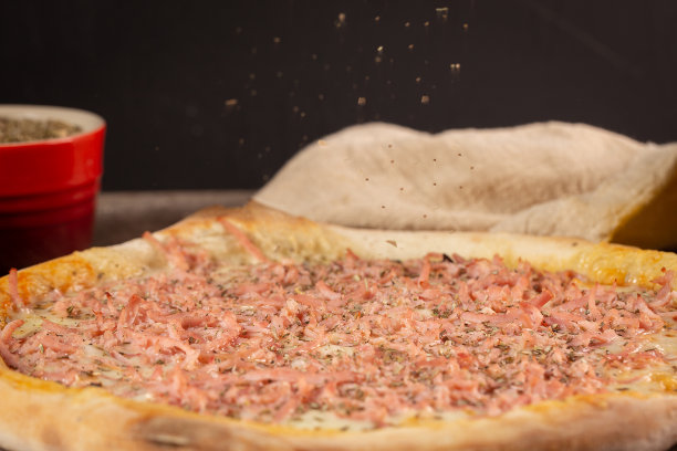 牛至叶落在火腿披萨上图片下载