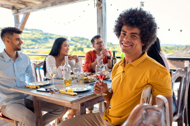 年轻男子与一群朋友在聚会上吃饭喝酒的照片。图片下载