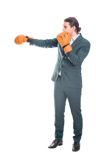 全副武装的商人穿着西装，戴着拳击手套，摆出一副战斗的姿势。办公室对峙，严肃的商务人士自我防卫孤立在白色背景上图片下载