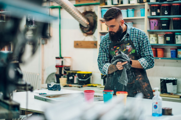 男工人在车间为丝网印刷调色图片下载