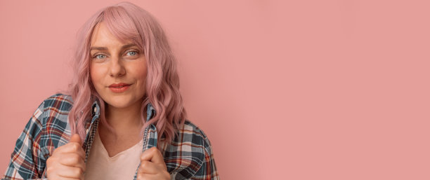 专注的年轻白人妇女看着在粉色粉彩背景与文本空间的相机图片下载