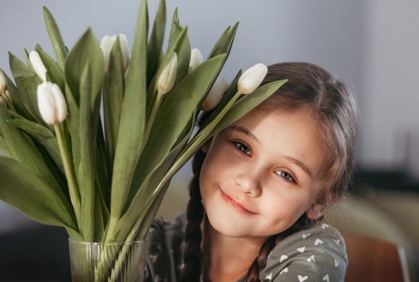 美丽漂亮的女孩的肖像与白色的花郁金香。室内的照片。图片下载