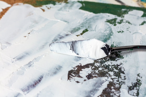 调色板刀与白色颜料在画布上图片下载