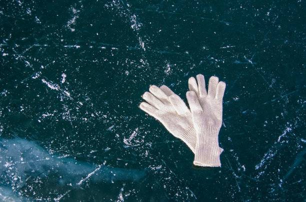 白套手套躺在冰冻的贝加尔湖上。寒假旅游理念图片下载