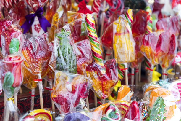 在商店的柜台上吮吸棒棒糖是五彩缤纷的。在圣诞市场买糖果。春节的五彩糖果图片下载