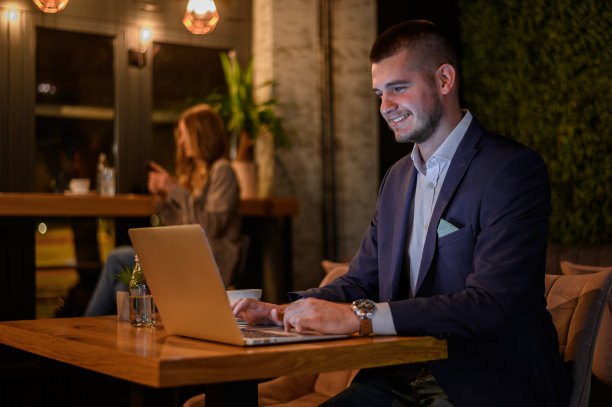 商人一边在咖啡馆喝咖啡，一边在笔记本电脑上工作图片下载