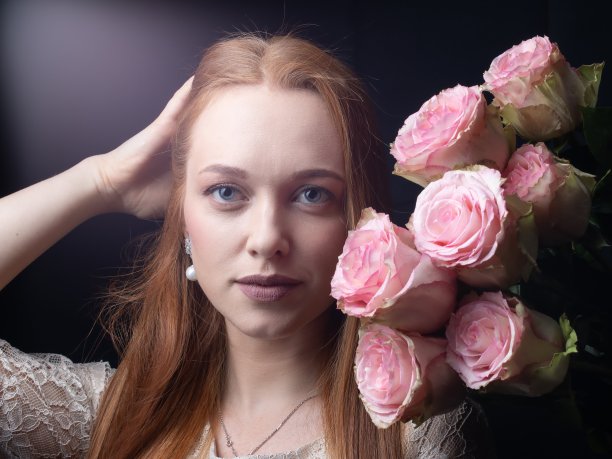 一个女孩的肖像与玫瑰在黑色的背景图片下载