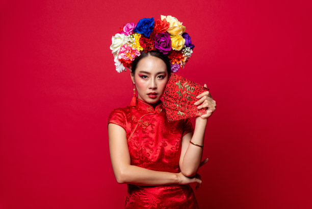 华丽的亚洲女人，穿着传统的东方服装，拿着红包或红包在孤立的背景中国新年的概念，外文翻译为巨大的运气和利润图片下载
