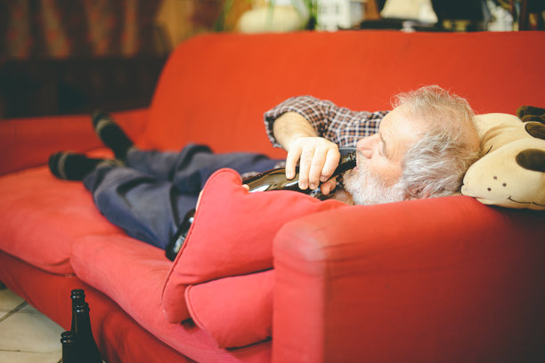 孤独的白人老人在家喝红酒图片下载