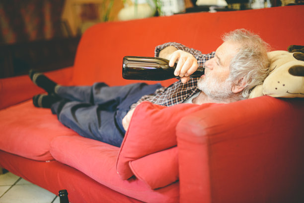 孤独的白人老人在家喝红酒图片下载