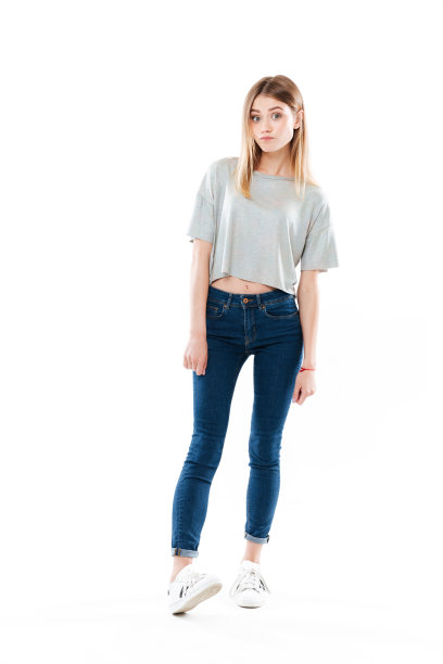 一个有趣的漂亮女孩站立和摆姿势的全长肖像图片下载