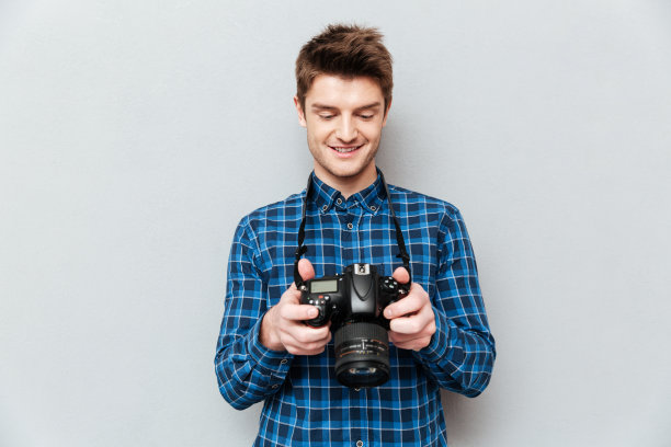 漂亮男人在看他的相机图片下载