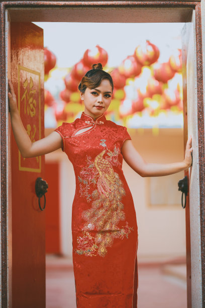 美丽的亚洲中国妇女穿着旗袍传统红色服装时尚张贴中国农历新年。图片下载