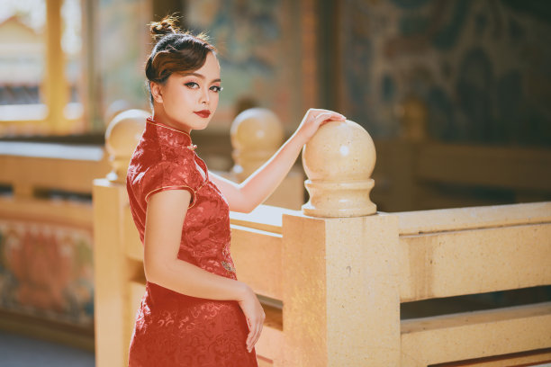 美丽的亚洲中国妇女穿着旗袍传统红色服装时尚张贴中国农历新年。图片下载