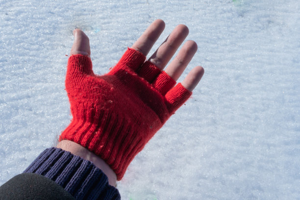 一个男人的左手在雪地上露出他的红色手套图片下载