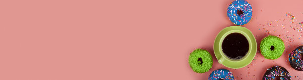 粉色背景的五彩甜甜圈和一杯咖啡。图片下载