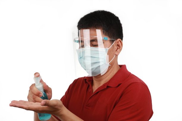 一名男子戴着面罩，用酒精凝胶洗手，以防止冠状病毒和细菌图片下载