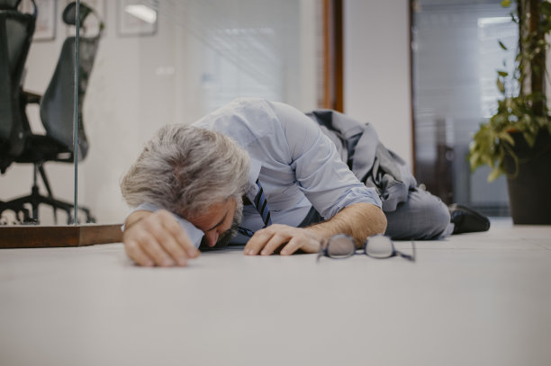 白发苍苍的资深商人在办公室心脏病发作图片下载