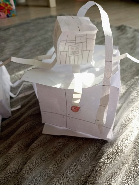 一张用纸剪出的昆虫的特写照片，并录制了一个学龄期的孩子的手工活动，剪纸和制作有趣的玩具，唤起生活和动物放在灰色的地毯上图片下载