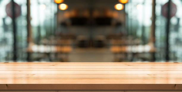 空的木制桌面与灯光散景在模糊的餐厅背景。图片下载