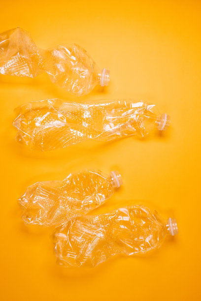 用过的塑料瓶黄色背景。生态问题。前视图。重复使用垃圾，回收利用，无塑料。图片下载