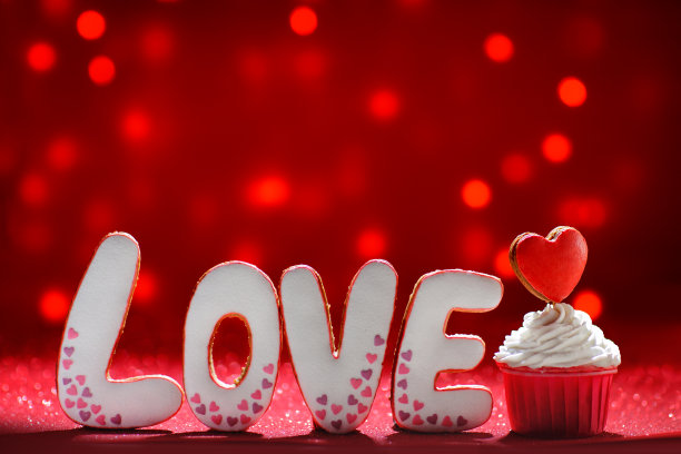 可爱的姜饼爱心字装饰和亮红色的心在松饼情人节图片下载