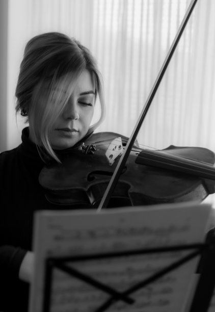 黑白照片的一个美丽的女孩演奏中提琴和肖像，近距离中提琴头部特写。图片下载