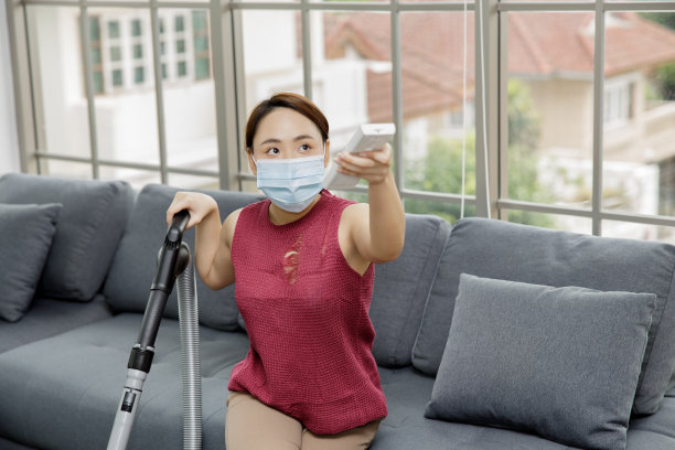 年轻女子拿着空调遥控器图片下载