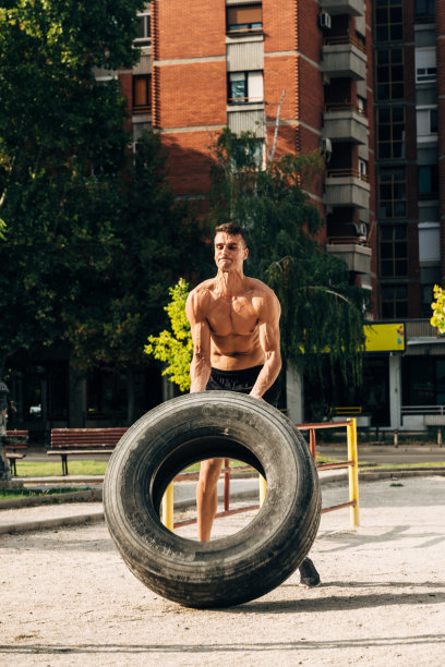 健身男运动员在户外进行翻胎综合健身图片下载