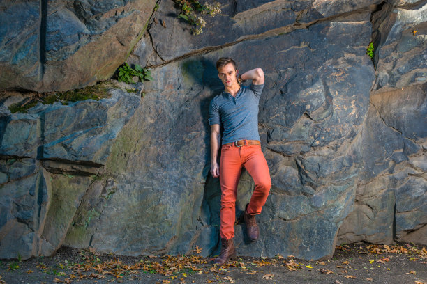 一个年轻人靠在大石头上，看着你。“r图片下载