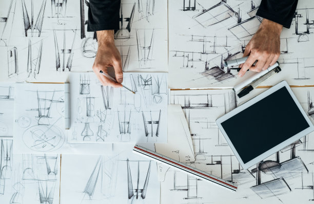 在设计工作室，设计师手绘制蓝图设计的桌面视图图片下载